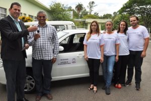 Ajudantes da Secretaria de Desenvolvimento Social recebendo as chaves do carro do vereador Eduardo Print Jr. (Foto: Geovany Correa)